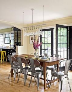 Shiny steel café chairs cozy up to a rustic Peruvian trestle table in this dining room.    #diningrooms #decoratingideas