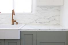 the apron sink is from Ikea—the Domsjo; $185.99—while the counter and backsplash is Calacatta Gold marble.