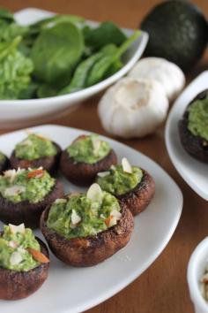 Spinach Avocado Stuffed Mushrooms!  1. Bake 8-10 baby portobello mushrooms (lightly drizzled with olive oil), cap up without stems in a preheated 450 degree oven for 7 minutes.  2. Blend the filling: 1 1/2 c spinach, 1 garlic clove, 1 medium avocado, 1/4 c walnuts, 1 tbsp each of nutritional yeast and lemon juice. Add salt for taste 3. Spoon into mushrooms and serve or stick it into the oven again at 450 degrees for 3-5 minutes 4. Add salt and almond garnishes for taste!