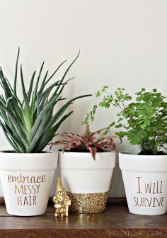 DIY Gold Foil Lettering on Flower Pots - Buy pots from the dollar store. Paint with whit acrylic paint. Wrap painters' tape around middle of pot. Brush Mod Podge on bottom. Sprinkle glitter. When fully dry (24 hours), brush more Mod Podge over glitter to set. Let dry. Gold letters done with  printable gold paper.