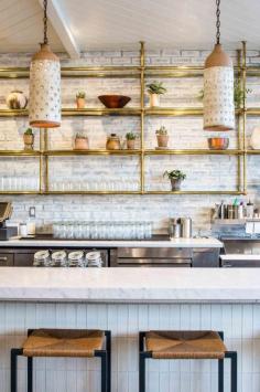 
                    
                        White & Gold Bar/Kitchen Inspiration. Brick Veneer. Brass Shelving with Glass Counters. Powder Coated Steel Stools. Marble Counter Tops.
                    
                