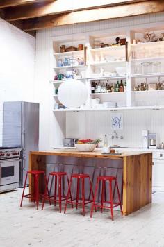
                    
                        A renovated New York loft. The red stools make a bright statement against the timber island. Photography by Gaelle Boulicaut.
                    
                