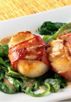 Turkey Bacon-Wrapped Scallops with Wilted Spinach — In this Healthy Living recipe, scallops are wrapped with bacon and drizzled with a savory mustard vinaigrette. Serve on wilted spinach and enjoy!