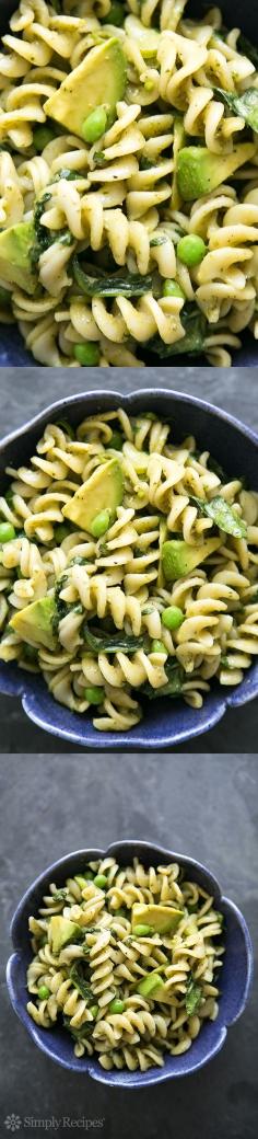 Vegan pasta with pesto, spinach, peas, and avocado.