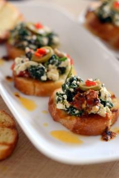 Warm feta and Spinach on golden baguette drizzled with chili oil. Use cashew cream in place of feta for a vegan version.