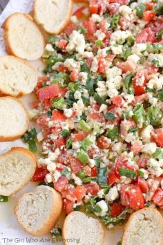 Easy Feta Dip •about 1/3 cup olive oil  •3 Roma tomatoes, seeded and diced  •4-5 green onions, sliced thinly  •8 ounces feta cheese, crumbled (see Note)  •2-3 teaspoons Cavender's Greek seasoning  •fresh baguette, sliced thinly