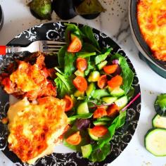 A delicious Greek veggie chickpea moussaka, made with layers of aubergine, courgettes and a chickpeas in a rich tomato sauce topped with a potatoes and an authentic creamy cheese topping served with a fresh tomato and green salad