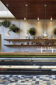 Prahran Hotel / Techne Architects Lighting hung from ceiling panels.  The wall plants soften the concrete tilt panels