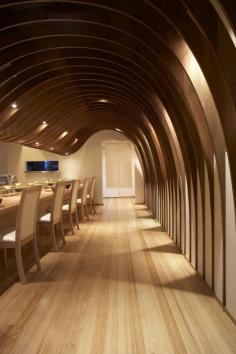 The cave restaurant by Koichi Takada Architects uses the rhetoric of "cellar" to create a warm and comforting ambiance for dining.  The wood paneling difuses sound and creates a warmth allowing for pleasant conversations and relaxed dining.