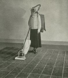 detail from Hoover : the story of a crusade. (1926)      The marks on the carpet show how long each stroke should be and a metronome guides her in making a given number of strokes per minute. By measuring her carbon—dioxide exhalation while she works, the amount of energy required to sweep with different devices and in different ways—slow, fast, long strokes, short strokes, etc.—is accurately determined.