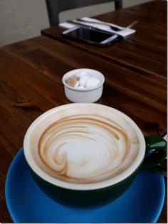 Flat white coffee with green cup and blue saucer at PROVENCE By Antoine. Read more on chopinandmysaucep...