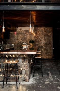 
                    
                        Reclaimed timber boards and sections of mesh fencing feature in this dimly-lit bar in Sydney
                    
                
