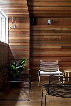 
                    
                        Wood panelled wall with horizontal stips and outdoor furniture in mezzanine of Super Whatnot in Brisbane
                    
                