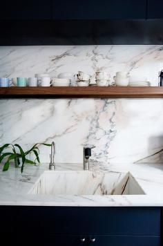 
                    
                        KITCHEN DETAIL: Marble and dark blue cabinetry.
                    
                