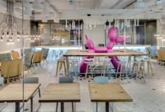 
                    
                        A pastry restaurant filled with rustic and modern furnishings and a giant pink balloon dog in the center.
                    
                