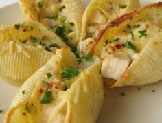 Great for an appetizer or a main dish. . Mini Chicken Alfredo  Makes 12 servings of 24 shells  24 dry jumbo pasta shells, (about 6 oz.) 2 Tbsp. olive oil 1 lb. boneless, skinless, chicken breast halves, seasoned with salt and pepper  Sauce: 1 1/2 c. heavy cream 2 cloves garlic, chopped 1 stick unsalted butter (8 Tbsp.) 1 1/2 c. grated Parmesan, divided 2 tsp. black pepper 4 Tbsp. chopped fresh parsley, divided  Preheat broiler with rack 5 inches from element. Spray two 24-cup mini muffin tins with nonstick spray; set aside. Bring a large post of salted water to a boil.  Cook shells in boiling water until al dente, 12-15 minutes; drain and rinse under cold water.  Heat oil in a skillet over medium heat. Add chicken and saute until cooked through, 8-9 minutes per side; cool slightly, then chop into small pieces.  Warm cream and garlic in a large saucepan over medium-low heat until steaming. Whisk in butter until melted. Add 1 c. Parmesan, 2 tsp. pepper, and 2 Tbsp. parsley. Increase heat to medium-high and simmer until reduced to 1 cup, about 10 minutes. Stir in chicken and remove from heat.  Fill each shell with 1 heaping Tbsp. chicken mixture. Stagger filled shells, open ends up, in every other muffin tin well to prevent them from sticking to each other. Sprinkle shells with remaining 1/2 c. Parmesan.  Broil shells until sauce bubbles and Parmesan melts and is golden, about 2 minutes. Garnish shells with remaining 2 Tbsp. parsley