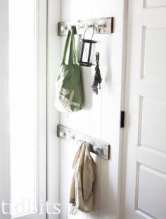 DIY coat hooks from old wood and decorative knobs, in an entry way.