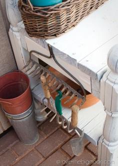 Old rake used for storing gardening tools on potting bench.  Great idea!