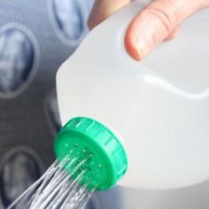 Make holes in the top of a used milk bottle for DIY watering can.