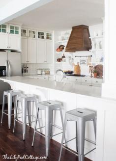 
                    
                        White Kitchen with wood range hood by The Lilypad Cottage
                    
                