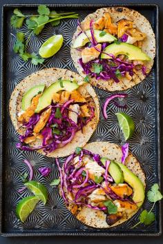 Grilled Fish Tacos With Cabbage Slaw and Avocado: Dress up tilapia fillets with a quick trip to the grill and irresistible taco toppings including avocado and red-cabbage slaw.