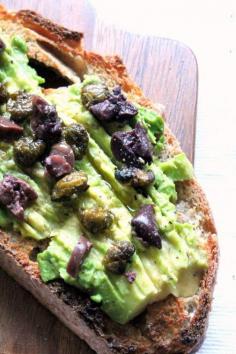 Avocado toast with a super flavorful twist! Kalamata olives and capers.